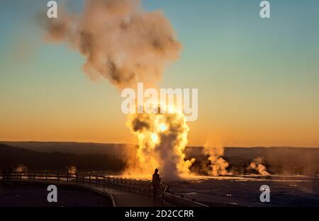 Le geyser de clopsydra éclate au coucher du soleil, bassin inférieur du Geyser, parc national de Yellowstone, Wyoming, États-Unis Banque D'Images