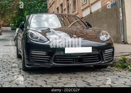 Tbilissi, Géorgie - juin 29 2019 : voiture Porsche noire dans la rue avec un pâté de maisons par une journée ensoleillée Banque D'Images