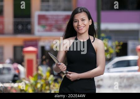 Jeune femme d'affaires latine souriant avec une tablette dans ses mains Banque D'Images