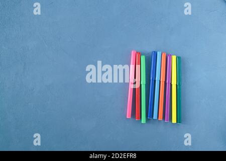 Marqueurs colorés sur fond bleu. Banque D'Images