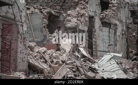 Taiz / Yémen - 13 avril 2017 : Yéménite devant des maisons détruites par la guerre et des combats violents dans la ville de Taiz, Yémen Banque D'Images