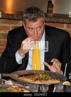 STATEN ISLAND, NY - JANVIER 10 : quand une pizza a été placée devant le nouveau maire, il a fait un mouvement fatidique : il a pris une fourchette et un couteau. Le maire de New York mange sa pizza comme un touriste. Le maire Bill de Blasio s'est rendu vendredi à Staten Island pour un déjeuner-rencontre à l'occasion d'un célèbre joint de pizza et a soulevé des sourcils en mangeant sa tranche avec un couteau et une fourchette. L’utilisation de coutellerie par de Blasio, plutôt que la méthode de pliage éprouvée de New York, l’a placé en minorité à une table de dix propriétaires de petites entreprises et locaux le 10 janvier 2014 à New York. Personnes: Le maire Bill de Blasio transmission Banque D'Images