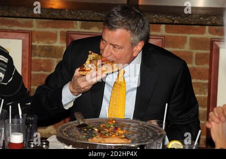 STATEN ISLAND, NY - JANVIER 10 : quand une pizza a été placée devant le nouveau maire, il a fait un mouvement fatidique : il a pris une fourchette et un couteau. Le maire de New York mange sa pizza comme un touriste. Le maire Bill de Blasio s'est rendu vendredi à Staten Island pour un déjeuner-rencontre à l'occasion d'un célèbre joint de pizza et a soulevé des sourcils en mangeant sa tranche avec un couteau et une fourchette. L’utilisation de coutellerie par de Blasio, plutôt que la méthode de pliage éprouvée de New York, l’a placé en minorité à une table de dix propriétaires de petites entreprises et locaux le 10 janvier 2014 à New York. Personnes: Le maire Bill de Blasio transmission Banque D'Images