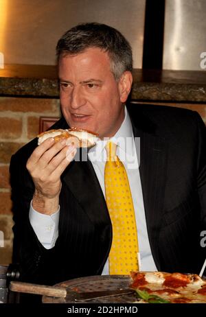 STATEN ISLAND, NY - JANVIER 10 : quand une pizza a été placée devant le nouveau maire, il a fait un mouvement fatidique : il a pris une fourchette et un couteau. Le maire de New York mange sa pizza comme un touriste. Le maire Bill de Blasio s'est rendu vendredi à Staten Island pour un déjeuner-rencontre à l'occasion d'un célèbre joint de pizza et a soulevé des sourcils en mangeant sa tranche avec un couteau et une fourchette. L’utilisation de coutellerie par de Blasio, plutôt que la méthode de pliage éprouvée de New York, l’a placé en minorité à une table de dix propriétaires de petites entreprises et locaux le 10 janvier 2014 à New York. Personnes: Le maire Bill de Blasio transmission Banque D'Images