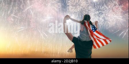 Vacances patriotiques. Enfant assis sur les épaules de son père et tenant le drapeau des États-Unis. L'Amérique fête le 4 juillet. Banque D'Images