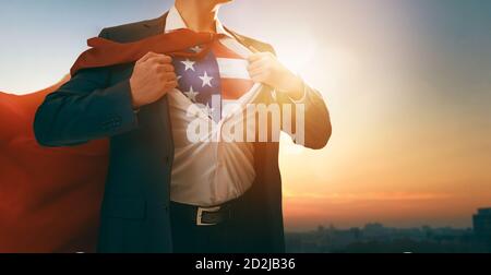 Vacances patriotiques. Heureux jeune homme d'affaires super-héros avec drapeau américain sur la poitrine. Les Etats-Unis célèbrent le 4 juillet. Banque D'Images