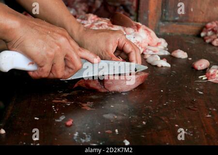 Boucher le poumon brut ou les abats de vache et de chèvre sur une planche à découper en bois avec couteau. Banque D'Images