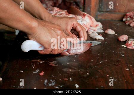 Boucher le poumon brut ou les abats de vache et de chèvre sur une planche à découper en bois avec couteau. Banque D'Images