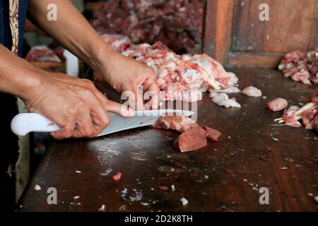 Boucher le poumon brut ou les abats de vache et de chèvre sur une planche à découper en bois avec couteau. Banque D'Images