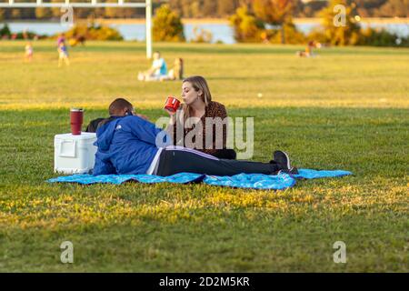 Arlington, va, Etats-Unis 10/02/2020: Un homme afro-américain et une femme caucasienne se détendent dans le parc de Gravelly point à un après-midi ensoleillé. L'interracial Banque D'Images