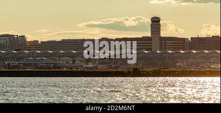 Washington DC, Etats-Unis 10/03/2020: Vue panoramique de l'aéroport national Ronald Reagan sur le fleuve Potomac au coucher du soleil. L'image présente la tour, les terminaux, p Banque D'Images