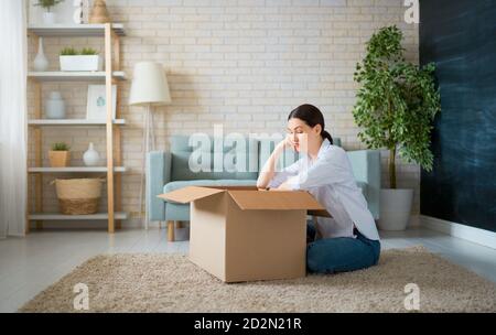 Belle jeune femme tient une boîte en carton à la maison. Banque D'Images