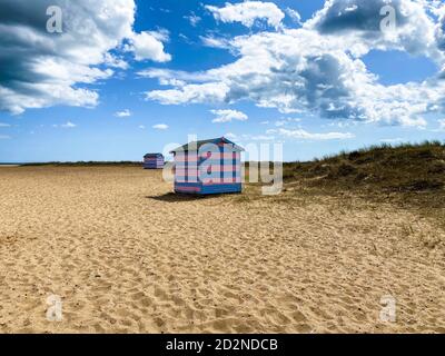 Cabines de plage Great Yarmouth en été, cabine britannique traditionnelle sur une côte est anglaise, bandes horizontales bleues et roses, ciel avec nuages Banque D'Images