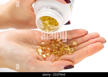 Les femmes main avec des capsules de gel de vitamine D . Vitamine Oméga-3 huile de poisson en capsules. Capsules de capsule transparentes à la main ou gel souple Banque D'Images