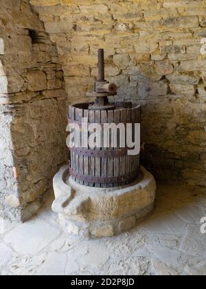 vieille presse à vin en bois, métal et pierre utilisée pour écraser les pains de raisins, fond de mur de pierre Banque D'Images