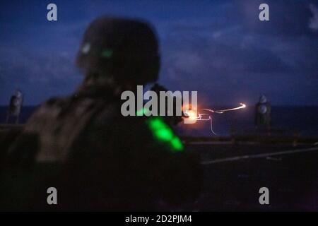 MER DES PHILIPPINES (oct 5, 2020) UNE Marine américaine avec une équipe de Bataillon d'atterrissage, 2e Bataillon, 4e Marines, 31e unité expéditionnaire maritime (MEU) tire un fusil automatique d'infanterie M27 (IRA) lors d'une séance de nuit à bord d'un bateau d'atterrissage sur quai USS Germantown (LSD 42). Germantown, qui fait partie du groupe de grève expéditionnaire Seven (ESG 7), ainsi que du 31e MEU, opère dans la zone de responsabilité de la 7e flotte des États-Unis pour améliorer l'interopérabilité avec les alliés et les partenaires et servir de force de réaction prête pour défendre la paix et la stabilité dans la région Indo-Pacifique. (É.-U. Photo du corps marin par Sgt. Danny Gonzalez) Banque D'Images