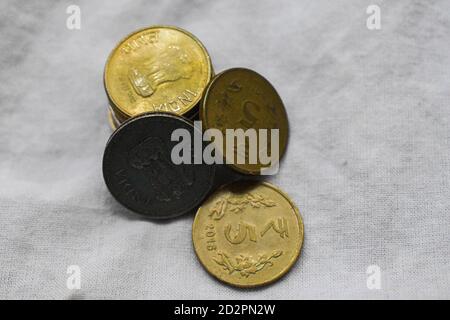 Les pièces de roupie indiennes sont réparties sur des feuilles blanches Banque D'Images