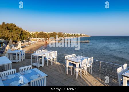 Restaurant de plage avec vue sur la mer au coucher du soleil sur la plage d'Akyarlar, Bodrum, Turquie. Banque D'Images