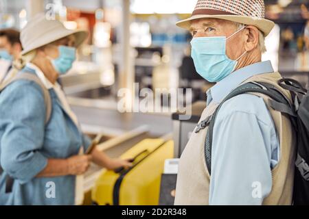 Couple senior utilisant un dépôt de bagages en libre-service Banque D'Images