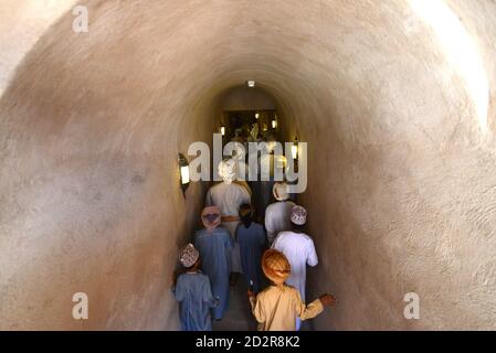 Les hommes omanais tiennent des épées sur leur chemin pour se produire au fort de Nizwa, Oman. Banque D'Images