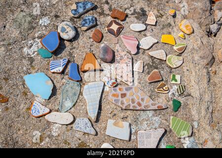 Morceaux de tuiles multicolores, arrondis par la mer. Peniche, Portugal Banque D'Images