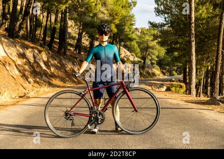 Femme mature entraînement vélo de route, escalade d'une route de montagne, montrant le vélo sur la route Banque D'Images