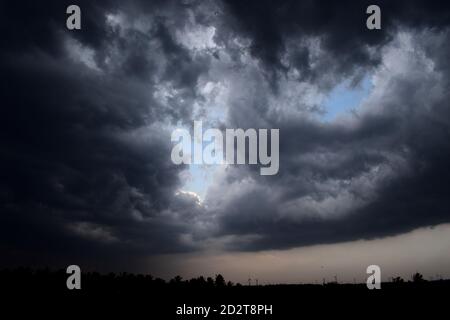 les nuages s'éloignent montrant le ciel bleu clair au-dessus des nuages sombres. de l'autre côté, il pleut une belle vue que j'ai pris beaucoup de temps a Banque D'Images