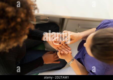 Vue de dessus d'une femme dentiste anonyme parlant avec le patient implants dentaires en clinique dentaire Banque D'Images