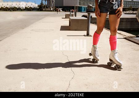 Patinage à roulettes féminin concentré sur le terrain de sport par beau temps en ville Banque D'Images