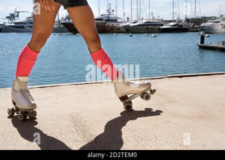 Patinage à roulettes féminin concentré sur le terrain de sport par beau temps en ville Banque D'Images