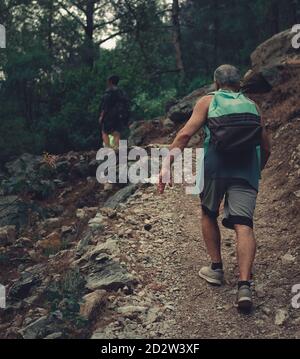 Homme senior grimpant sur le sentier dans le parrest. Image d'un randonneur de l'arrière dans la nature. Banque D'Images