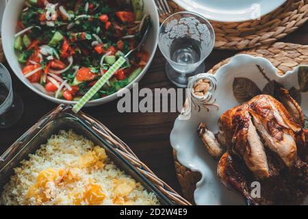 Poulet rôti entier avec riz et salade servi sur la table. Banque D'Images
