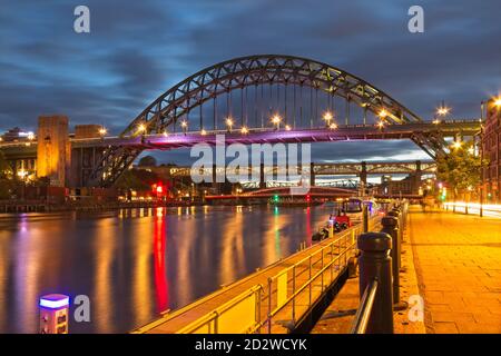 Vue sur la rivière Tyne au crépuscule depuis le quai de Newcastle vers le pont emblématique Tyne, le pont Swing et le pont High Level. Banque D'Images