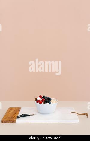 Grand angle de bol nutritif avec muesli et diverses baies dans un bol placé sur la table pour le petit déjeuner le matin Banque D'Images