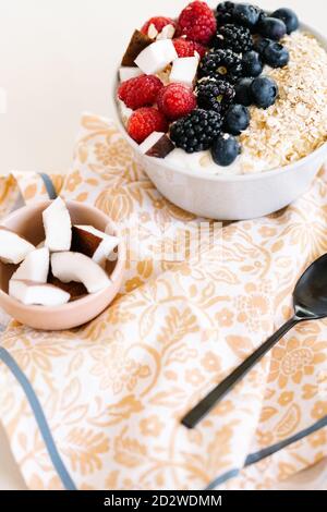 Grand angle de bol nutritif avec muesli et diverses baies dans un bol placé sur la table avec une serviette pour le petit déjeuner matin Banque D'Images