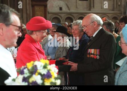 La Reine remet l'argent Maundy traditionnel au retraité Roy Burton, 74 ans, à l'intérieur de la cathédrale de Norwich. Photo de Chris Harris/The Times Rota/PA. VOIR PA STORY ROYAL MAUNDY. Banque D'Images