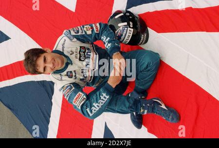 Damon Hill, pilote du Grand Prix Williams, pose une posture patriotique lors d'une pause dans l'essai de sa nouvelle FW18 à Brands Hatch dans le Kent. * 01/09/96: L'avenir de la Formule 1 de Hill a été mis en doute quand il a été révélé que son équipe Williams-Renault avait mis fin aux négociations de contrat. Hill, qui pourrait conclure le championnat du monde de pilotes lors du Grand Prix d'Italie de dimanche prochain, est maintenant à la recherche d'une autre équipe pour la saison prochaine, a déclaré à une conférence de presse ce matin son avocat Michael Breen. Williams a maintenant l'air de signer officiellement le pilote allemand très bien noté Heinz-Harald Frentzen à son partenaire Jacques V. Banque D'Images