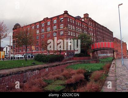 Des buissons surcultivés se trouvent dans l'ancien canal Rochdale, sous les usines Royal et Murray de Manchester, à Ancoats, qui ont été officiellement déclarés bâtiments classés par le ministre du Patrimoine Lord Inglewood lors d'une réunion du Fonds du patrimoine architectural à Manchester. * ils font partie de trente anciens bâtiments de moulin répartis autour du Nord-est que le gouvernement a l'intention d'ajouter aux soixante déjà inscrits comme d'intérêt historique spécial. Banque D'Images