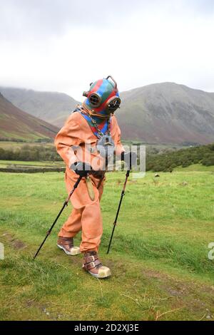 Lloyd Scott, ancien collecteur de fonds, qui tente de grimper les trois sommets tout en portant un costume de plongée en haute mer, lors de son défi sur Scafell Pike, dans le parc national de Lake District, Cumbria. Banque D'Images