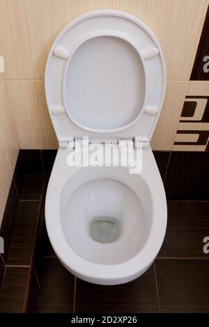 Toilettes avec un siège surélevé sur le fond de l'abstrait carreaux bruns avec un motif Banque D'Images
