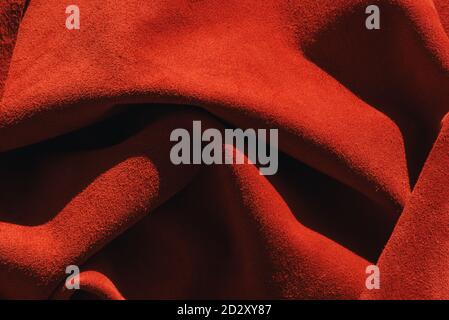 Arrière-plan rouge mat en daim, gros plan. Texture velours de cuir sans couture. Macro en feutre. Texture rouge. Banque D'Images