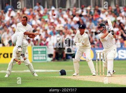 Le gardien de cricket d'Angleterre Alec Stewart (au milieu) regarde comme le coéquipier Mark Butcher (à gauche) bondit dans les airs après avoir été frappé sur le pied par une balle du batteur australien Steve Waugh (à droite) le deuxième jour du sixième test à l'Oval aujourd'hui (vendredi). Photo par Rebecca Naden/PA. Voir PA Story CRICKET England. Banque D'Images