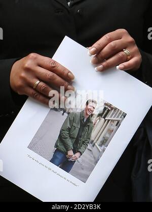 Un pleureur tient un ordre de service après les funérailles du photographe Tim Hetherington, tué lors d'une attaque au mortier en Libye, à l'église de l'Immaculée conception à Mayfair, Londres. Banque D'Images
