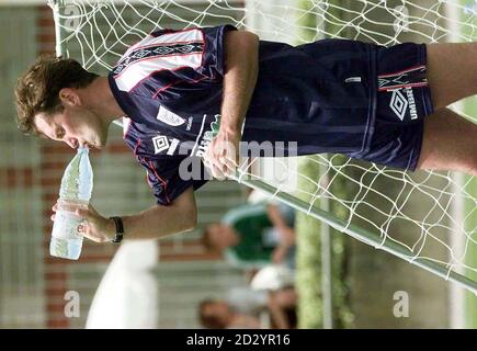 L'entraîneur d'Angleterre Glenn Hoddle prend un verre lors d'une séance d'entraînement chaude au soleil cet après-midi (mercredi) au Baule près de Nantes, en France. Angleterre jouer leur 2ème partie dans la coupe du monde lundi prochain (22 juin) contre la Roumanie à Toulouse. Photo par Adam Butler/PA Banque D'Images