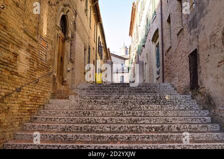 Un escalier dans un village italien avec une poubelle jaune (Corinaldo, Marche, Italie, Europe) Banque D'Images