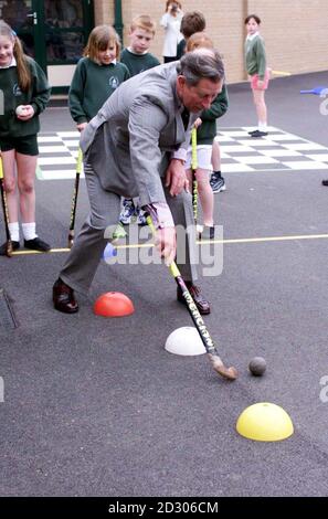 Le Prince Charles joue au hockey avec des élèves lors d'une visite à l'école primaire Sherborne de Dorset. Banque D'Images