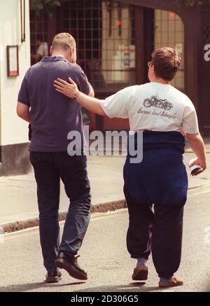 Une main réconfortante est offerte comme un membre du public semble angoissée après avoir visité le site de l'explosion de la bombe à ongles le vendredi 30 avril 1999. Le tronçon de 50 mètres de Old Compton Street où une bombe a explosé dans le pub Admiral Duncan a été rouvert au public. Banque D'Images