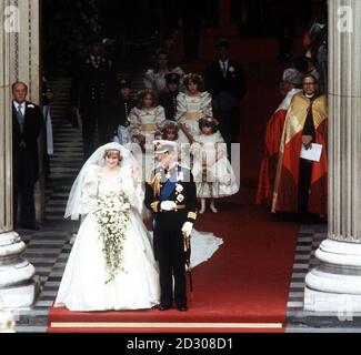 La princesse de Galles, l'ancienne dame Diana Spencer, se délase devant la foule alors qu'elle quitte la cathédrale Saint-Paul à Londres avec son mari, le prince de Galles, après leur cérémonie de mariage.La robe de la princesse a été conçue par Elizabeth et David Emanuel.* a un train détachable de 25ft de long.Son voile de tulle en soie ivoire, étoilé par des milliers de petites paillettes nacre brodées à la main, est maintenu en place par le tiara de diamant de la famille Spencer. Banque D'Images