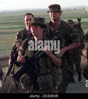 Une jeune femme soldat marche avec des troupes à la périphérie de Pristina, la capitale du Kosovo. 24/12/00: L'Armée de terre a fait un pas de plus vers la possibilité pour les femmes de servir dans des rôles de combat de première ligne. * les essais sur le terrain pour évaluer si les femmes pouvaient se battre aux côtés des hommes ont constaté que les deux sexes interagissaient bien dans presque toutes les situations, selon un rapport de l'Observateur. Les tests, effectués sur la plaine de Salisbury à l'automne, font partie d'un programme en trois phases qui déterminera si l'obstacle aux femmes qui servent sur le front devrait être supprimé. Un rapport sera présenté Banque D'Images