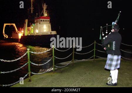 Un joueur solitaire voit dans le bateau Scotian Shore transportant les cadavres des sept victimes de la Solway Harvester sur le quai de Douglas, île de Man. Banque D'Images